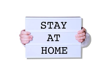 Male hands with Stay At Home sign on white background. Minimal art style.の写真素材