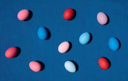 Painted eggs on blue background. Creative minimal concept.の写真素材