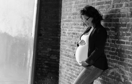 maternity picture of a woman in front of a wall in black and whiteの写真素材