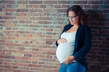 maternity picture of a girl in front of a wallの写真素材