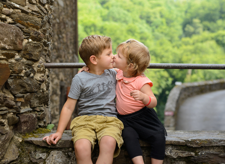 Lovely and adorable brother and sister girl giving each other a kiss, family loveの写真素材