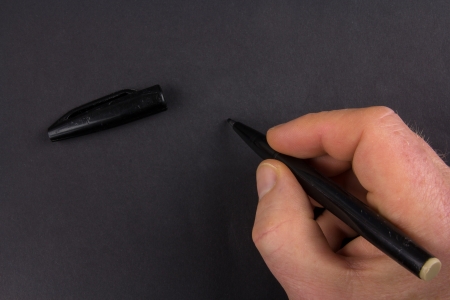 Hand writing on black paper with black pen - space for your text