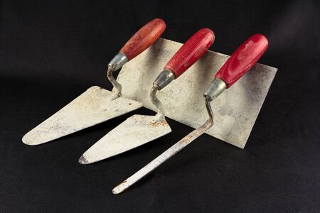 Dirty masonry tools on a black surfaceの写真素材