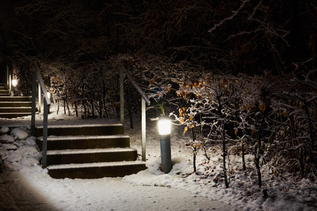snow covered lit pathway with stairs, shot in the darkの写真素材