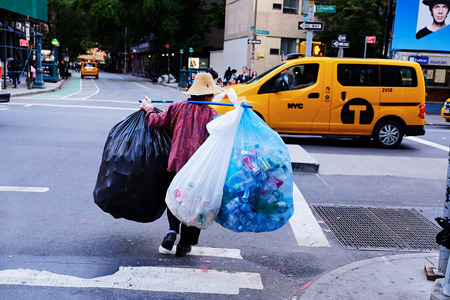 Person collecting a lot of bottles and cans in the streets of Manhattan