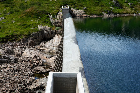 Looking down on the top of a concrete dam in a stream in Telemark Norway