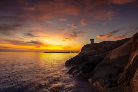 A colorfull sunset with the small lighthouse at StÃ¥ngehuvud in western Swedenの写真素材