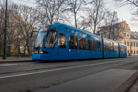A modern tram is passing a park in central Krakow in Polandのeditorial素材