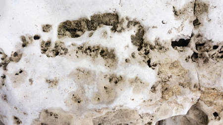 Natural rough travertine stone with cracks and grooves. White background of light stone travertine...