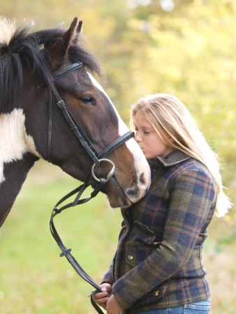 A girl kisses her horse on the nose.の写真素材