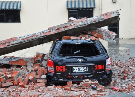 Christchurch, New Zealand - March 2011: A car is crushed by a collapsed brick wall on March 20, 2011 in Christchurch following a 6.2 magnitude earthquake.のeditorial素材