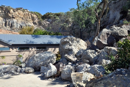 Christchurch, New Zealand - March 25: Hundreds of tons of rocks, loosened by an earthquake, fell from the cliffs at Redcliffs on March 25, 2011 in Christchurch. Houses below the cliffs were crushed and buildings at the top are now too dangerous to occupy.のeditorial素材