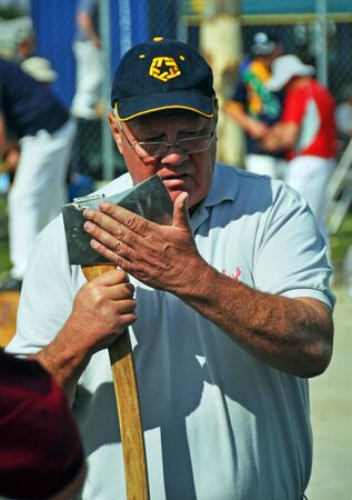 Christchurch, New Zealand - November 16, 2012: Competitor sharpens his axe at the 2012 Canterbury A&P Show wood chopping competition. のeditorial素材
