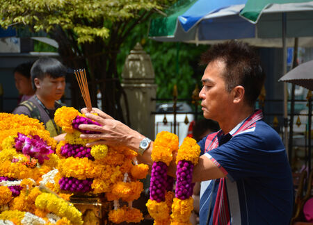 Bangkok, Thailand - September 23, 2014: Man makes a ceremonial offering at the famous   Erawan, Hindu Religious Shrine in  Bangkok.のeditorial素材