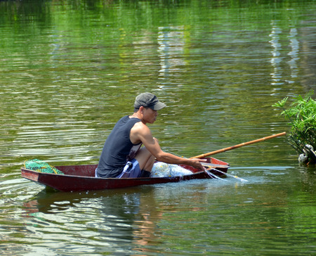 Hanoi Vietnam  April 13 2015: Fisherman tending his nets in a boat on the West Lake in Hanoi.