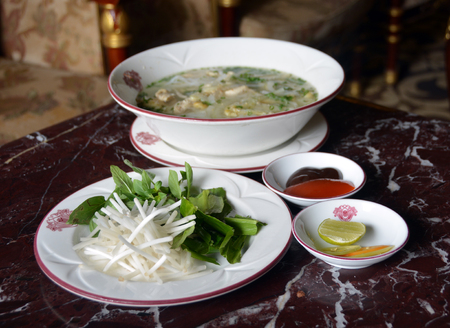 Ho Chi Minh City, Vietnam - April 05, 2015: Chicken Noodle Soup (Pho Ga) is the national dish in Vietnam. It is served here at the Majestic Hotel  with Chilli sauce, Limes, Chillies, Bean Sprouts and Lemon Grass which may optionally be added to the soup.のeditorial素材