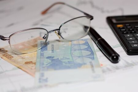 Glasses, euro, pen and calculator on graph from Forex 