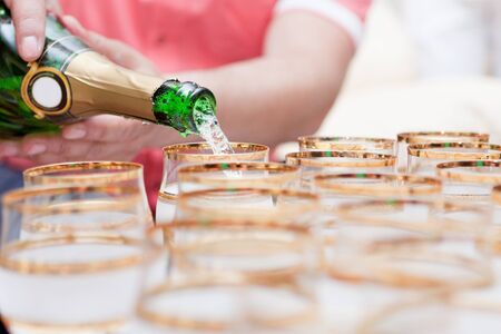 champagne is poured into glasses at the wedding の写真素材