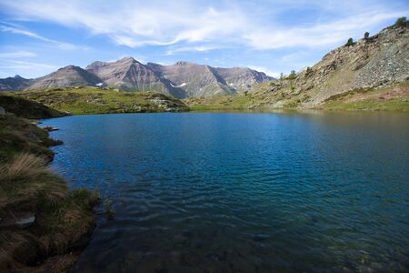 Clear blue mountain lake Lago di Loie in summer, Lillaz, Cogne, Aosta valley, Italyの写真素材