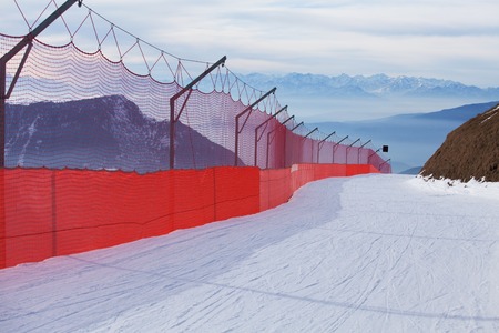 Skiing slope bordered with red net, Dolomites, Italyの写真素材