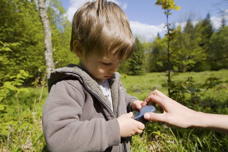 Caucasian toddler holding gps navigator in the mountainsの写真素材