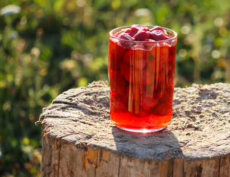 Fresh strawberry in the glas cup on a tree stump