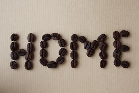 Home word written of coffee beans on aged brown paper textureの写真素材