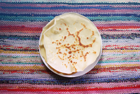 Stack of delicious pancakes on country striped homemade mat background
