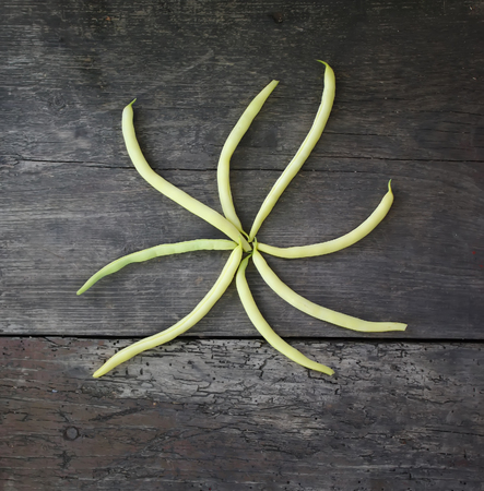 Green beans on wooden surface. Close up top view.