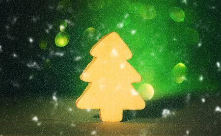Small decorative wooden christmas tree on sparkling glitter backgroundの写真素材