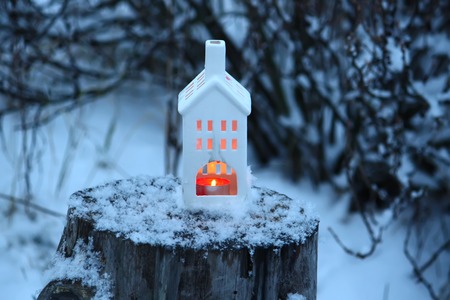 Christmas lantern with burning candle on winter nature background.の写真素材