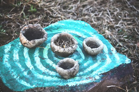 Handmade ceramic cups on a painted stone surfaceの写真素材