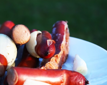 Sausages for a picnic on a white plate outdoorsの写真素材