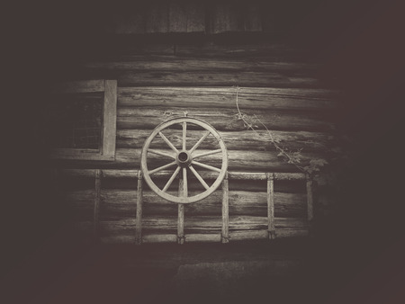 Old wooden wheel on the wooden wallの写真素材
