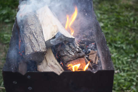 Burning firewood in the fireplace at evening in the rural yard.