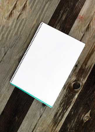 White paper sheet in a pad on the wooden table outdoorsの写真素材