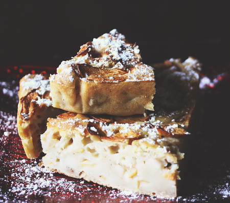 Homemade sweet apple pie with cinnamon and and powdered sugar.
