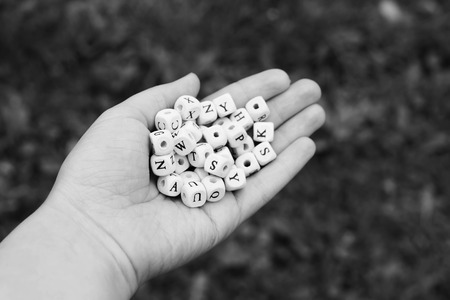 Wooden alphabet beads in a hand. Black and white photo.の写真素材