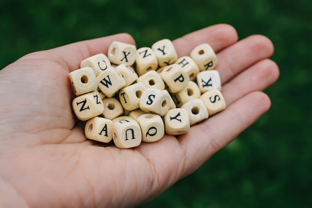 Wooden alphabet beads in a hand.の写真素材