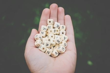 Wooden alphabet beads in a hand.の写真素材