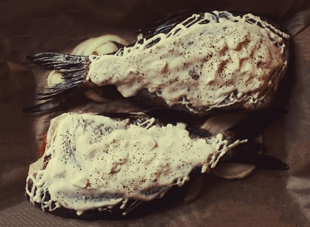 Fresh fish with mayonnaise, onion and flavouring prepared for baking.の写真素材