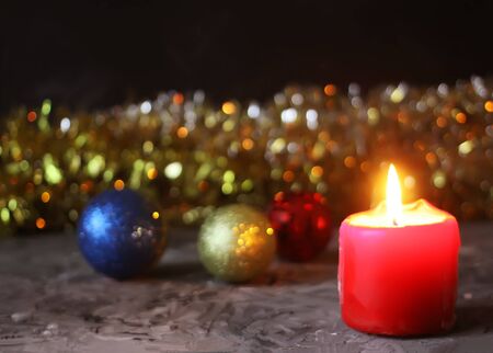 Burning red candle on christmas decoration background.の写真素材