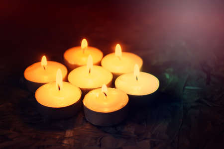 Burning candles on dark background.