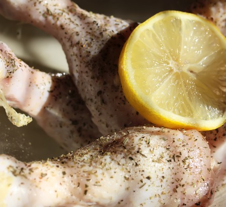 Raw chicken legs with herbs and lemon slice prepared for cooking.の写真素材