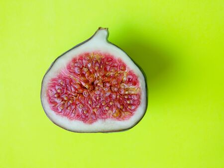 Ripe fresh sweet figs slice on bright yellow background.の写真素材