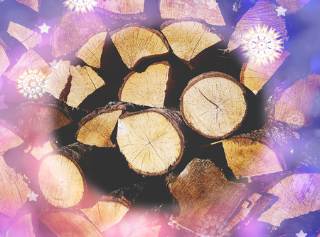 Chopped firewood on a stack. Pile of wood logs. Festive glitter and snow effect.の写真素材