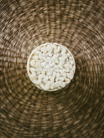 White flat round rice crackers on whicker place mat background.