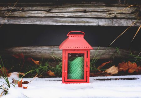 Decorative red lantern with green candle in autumn park at evening.の写真素材