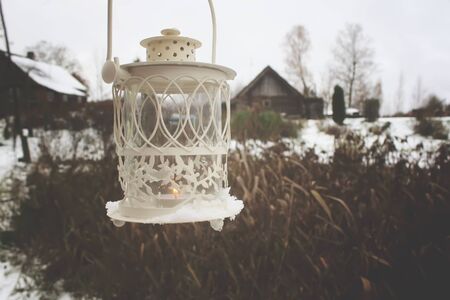 Decorative lantern with burning candle in autumn park at evening.の写真素材