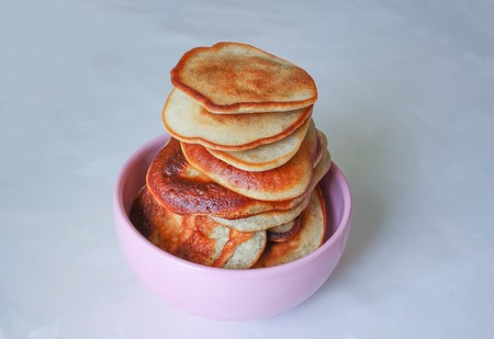 Pancakes in ceramics cup on a white tablecloth.の写真素材